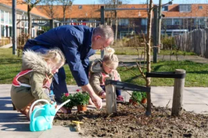 Wethouder Pieter Kos plant bomen met leerlingen.